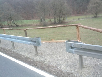 Öffnung in der Leitplanke mit Blick auf den Weg